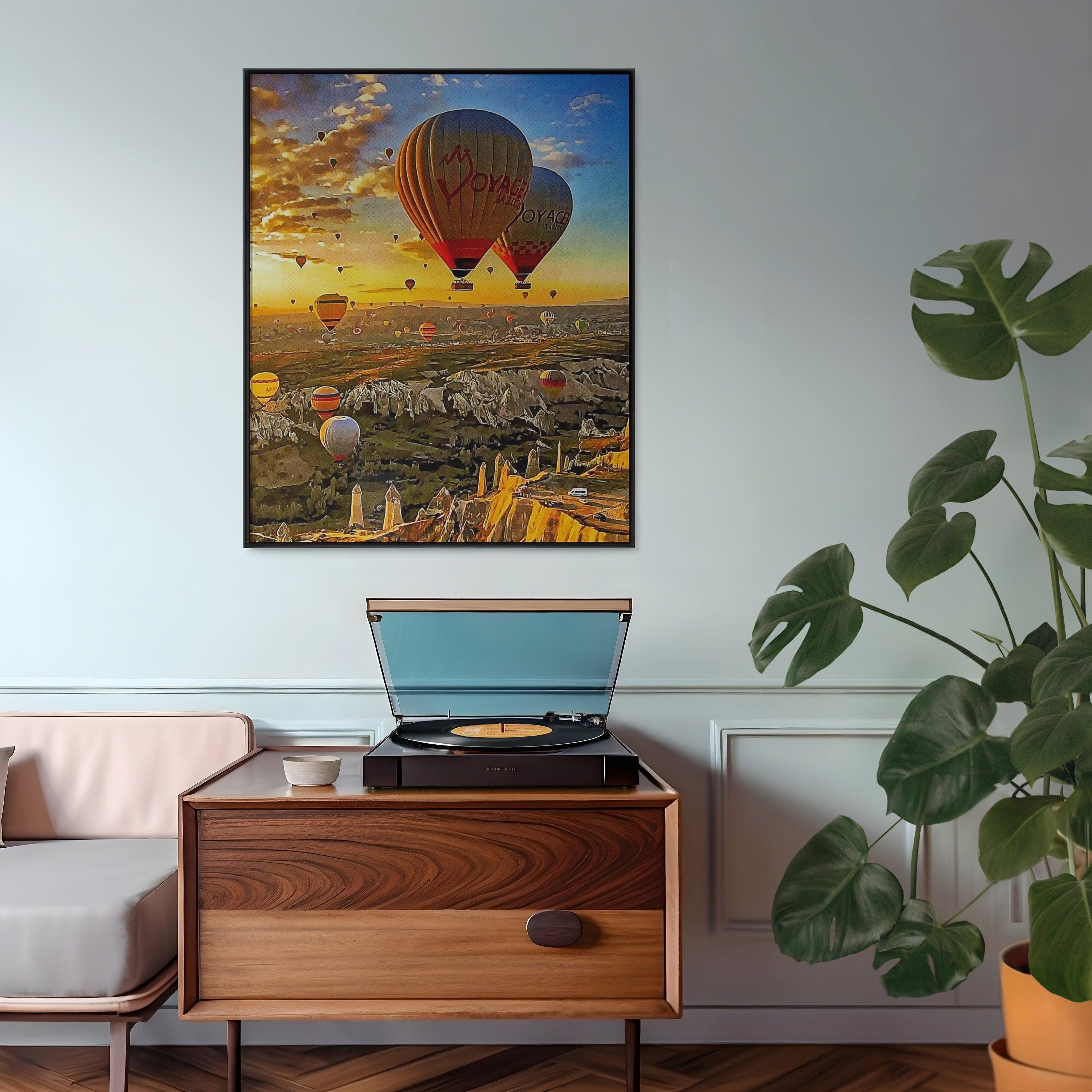 Framed Cappadocia balloon print in black above a walnut sideboard with record player in a pastel living room