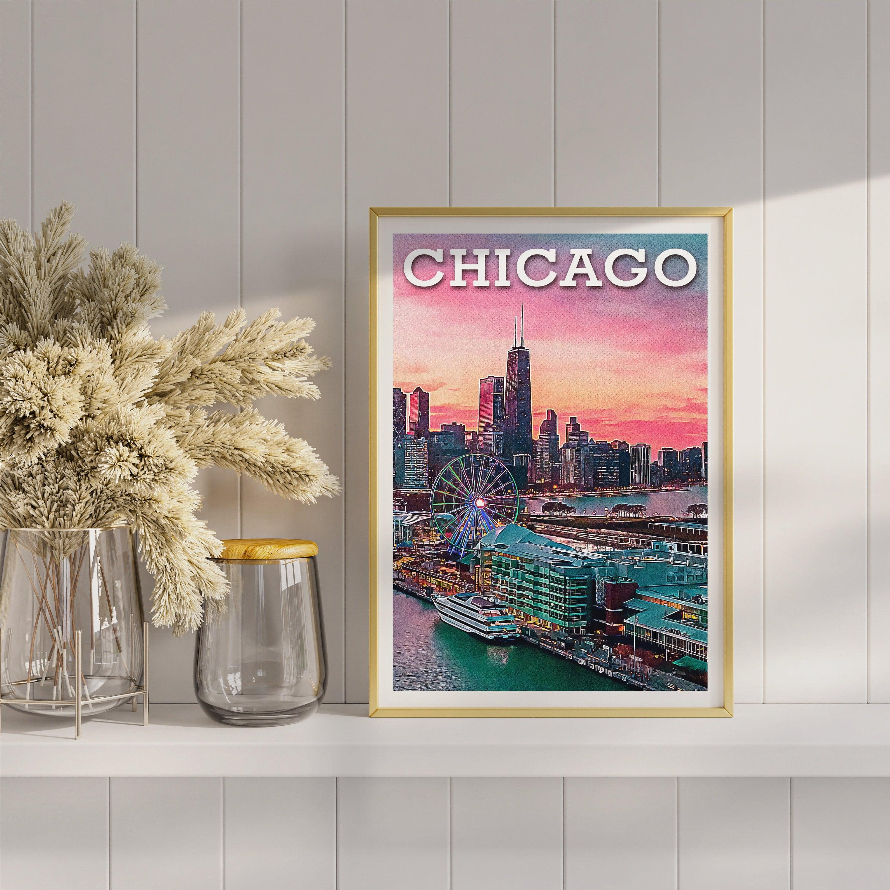 Gold framed Chicago sunset poster on a white shelf beside dried flowers and glass vases