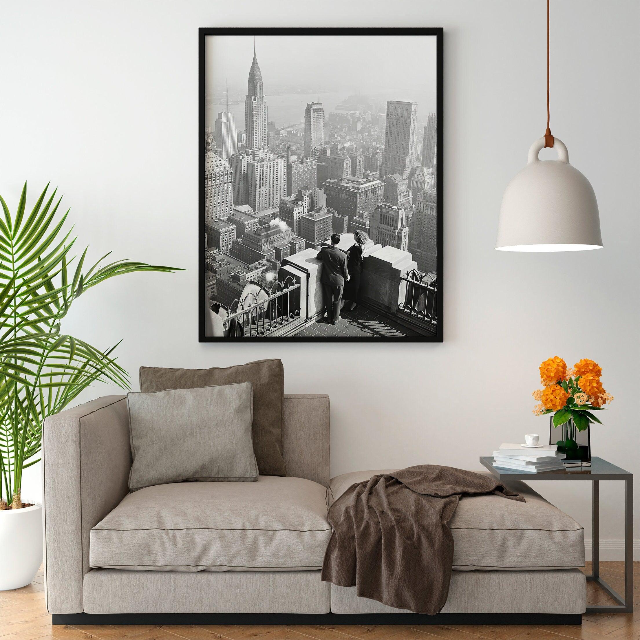 Black and white New York cityscape print hanging above a beige linen sofa