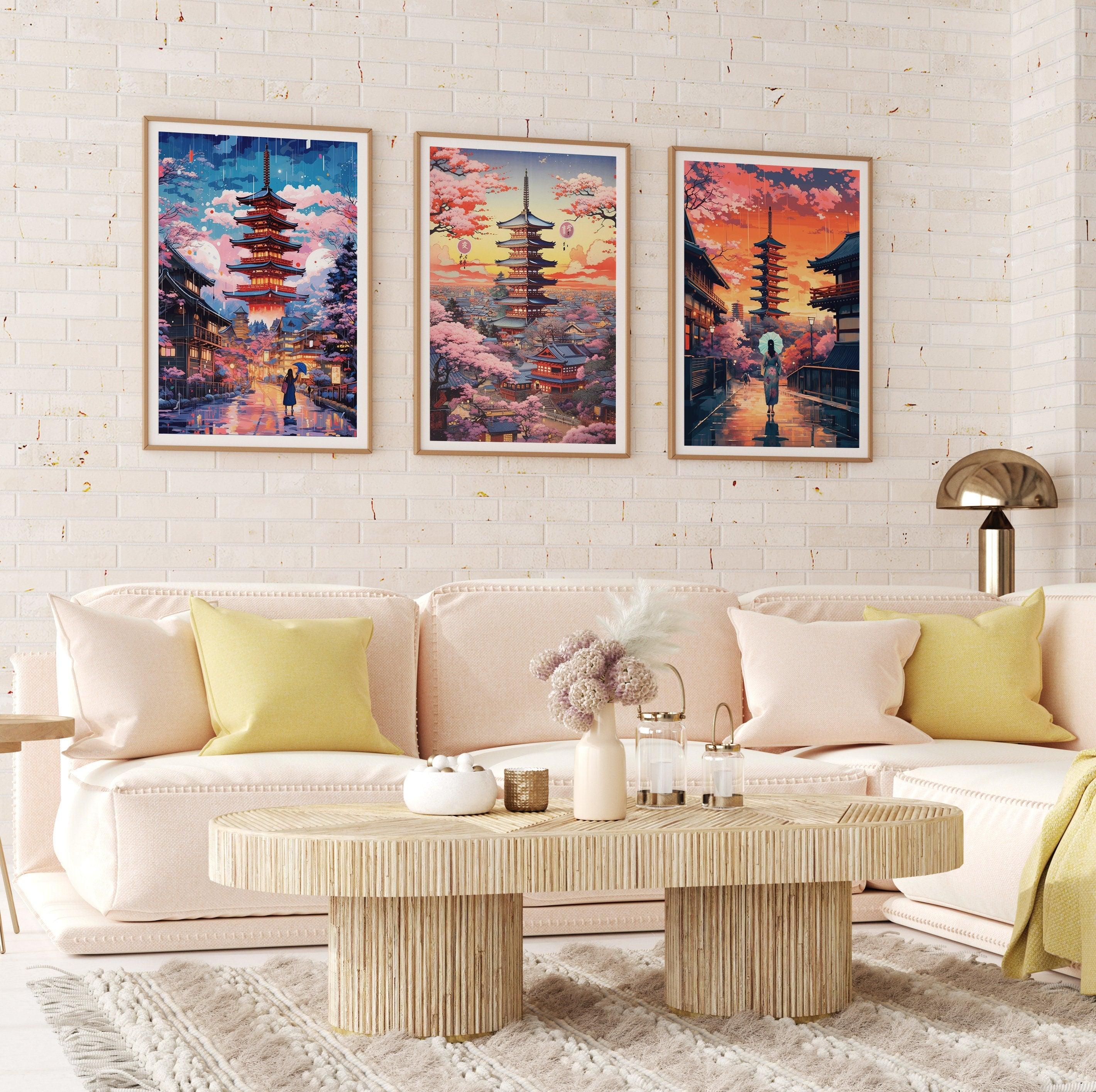 Three Japanese travel posters in wood frames over a blush sofa on white brick