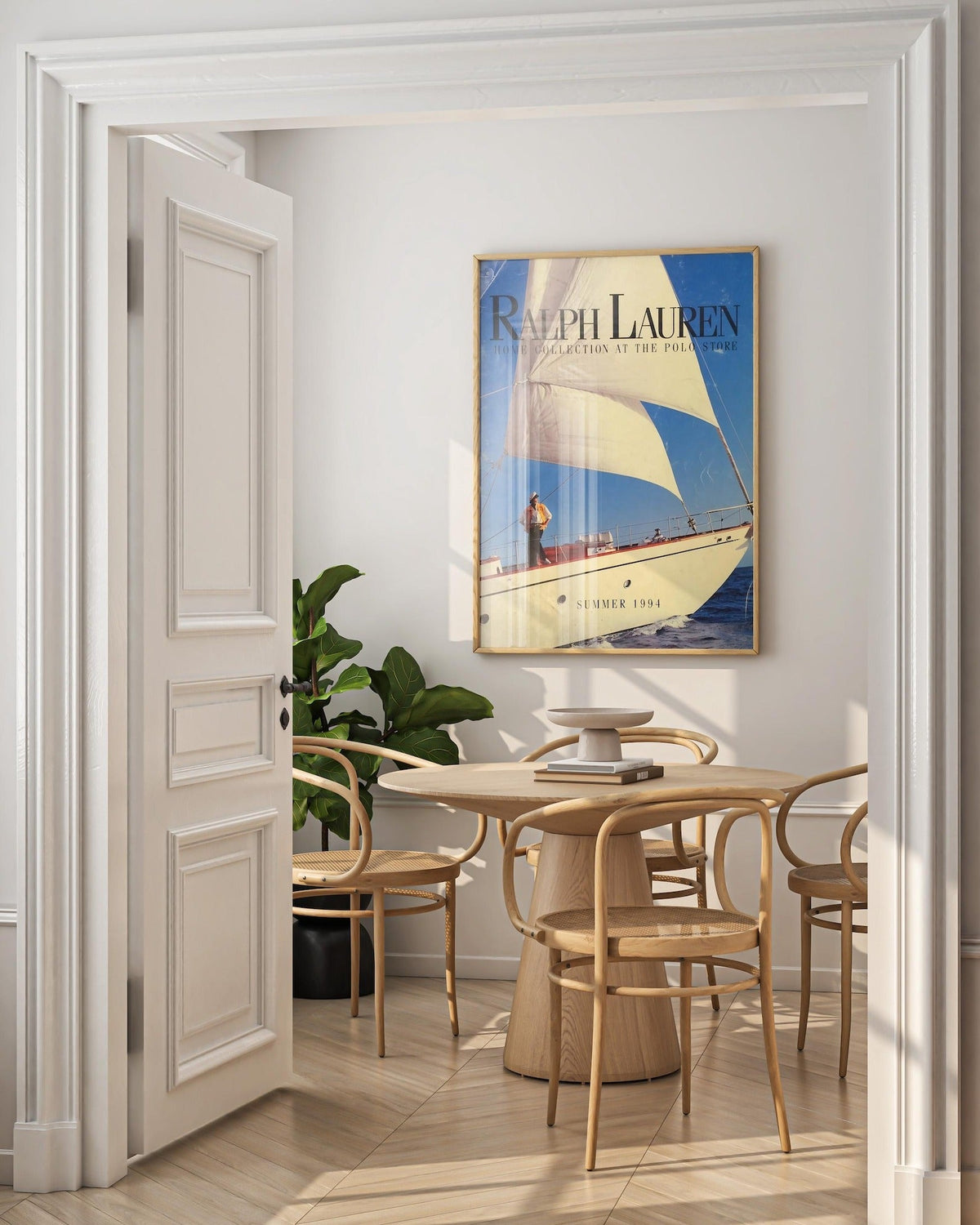 Oak framed sailboat poster with Summer 1994 caption on dining room wall above cane chairs